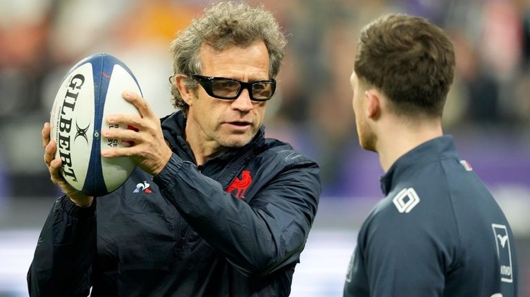 French coach Fabien Galthie, left, gestures holding the ball during...