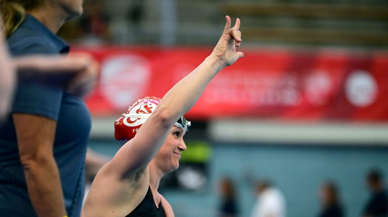 Christie Raleigh Crossley raises her hand before swimming the Women's...