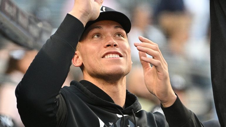 The Yankees' Aaron Judge looks on from the dugout before...