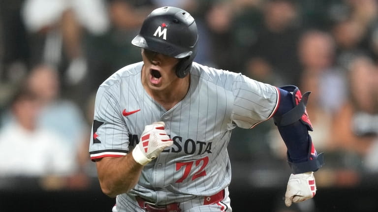 Minnesota Twins' Brooks Lee reacts after his RBI single in...