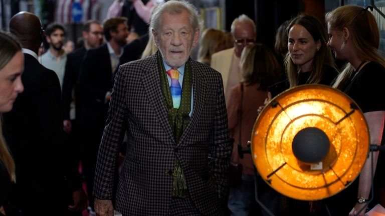 Ian McKellen, walks towards the photographers upon arrival at the...