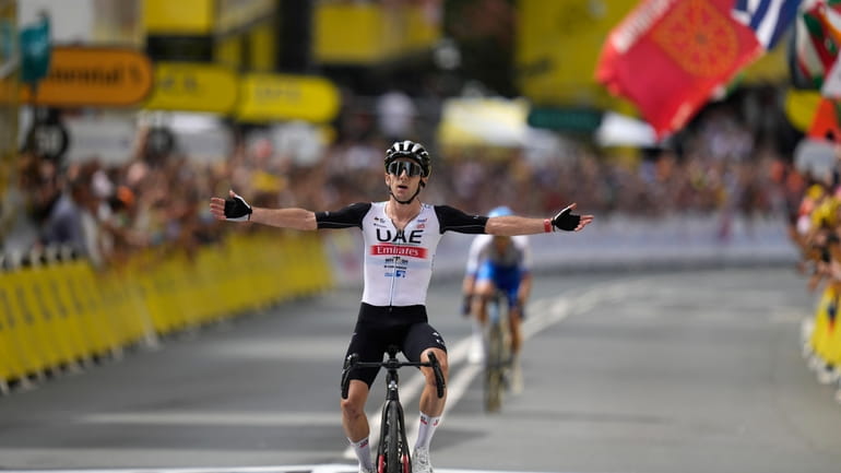 Britain's Adam Yates celebrates after crossing the finish line of...