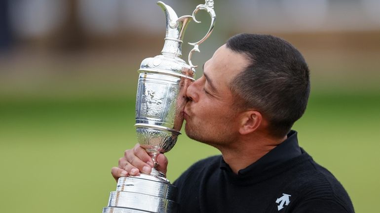 Xander Schauffele of the United States kisses the Claret Jug...