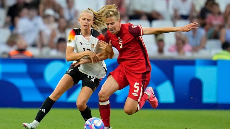 Germany's Laura Freigang fights for the ball with Canada's Quinn...