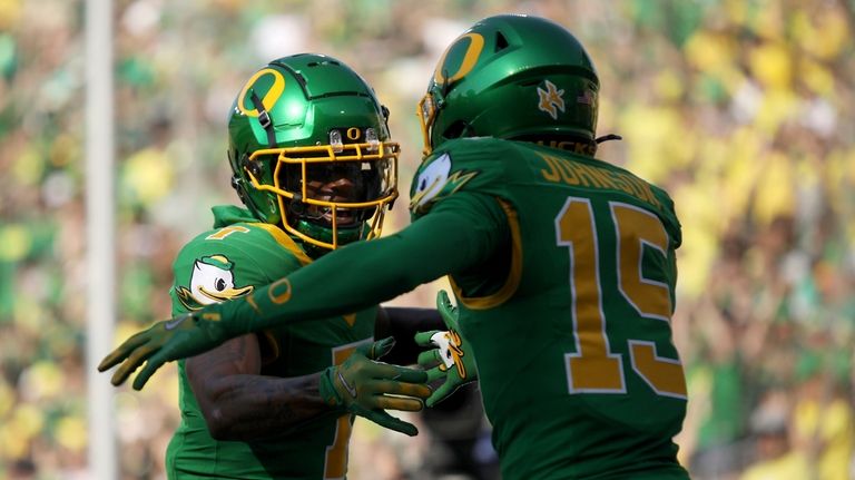 Oregon wide receivers Evan Stewart (7) and Tez Johnson (15)...