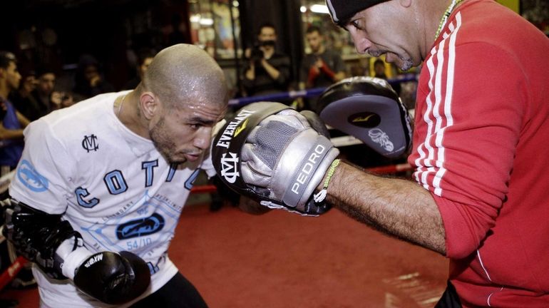 Miguel Cotto, left, of Puerto Rico, spars with his trainer...