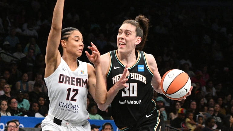 Liberty forward Breanna Stewart drives to the basket defended by...