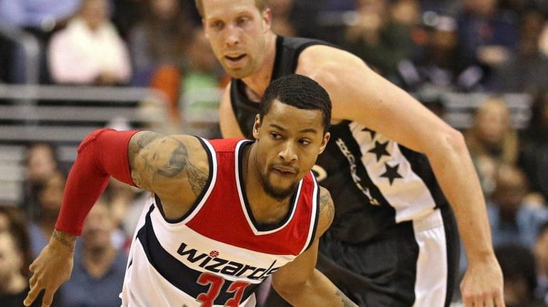 Trey Burke of the Washington Wizards dribbles up the court...
