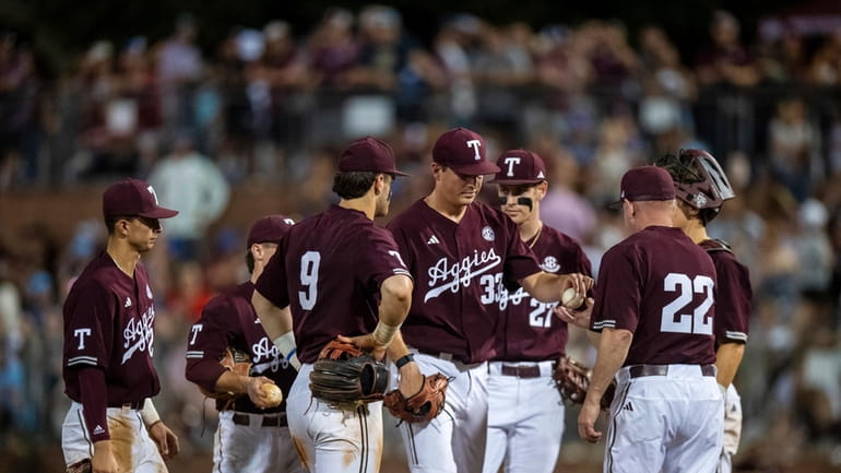Texas A&M pitcher Justin Lamkin (33) hands the ball over...