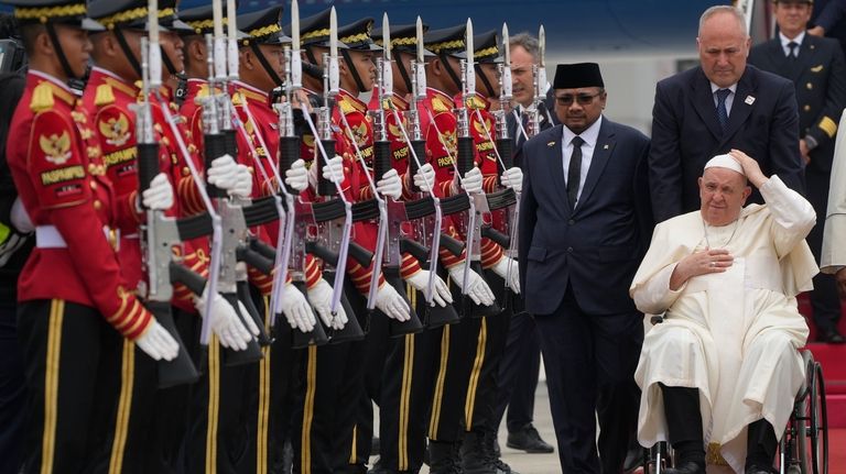 Pope Francis is welcomed by Indonesia's Minister for Religious Affairs...