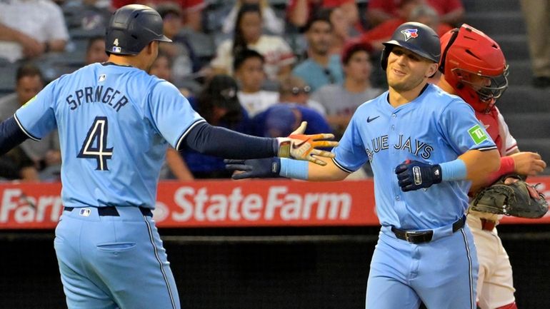 Toronto Blue Jays' Daulton Varsho is congratulated by George Springer...