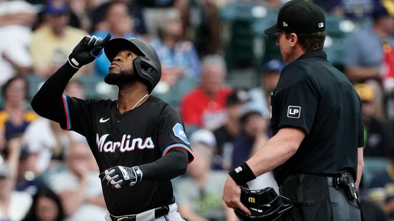 Miami Marlins' Bryan De La Cruz, left, gestures after hitting...