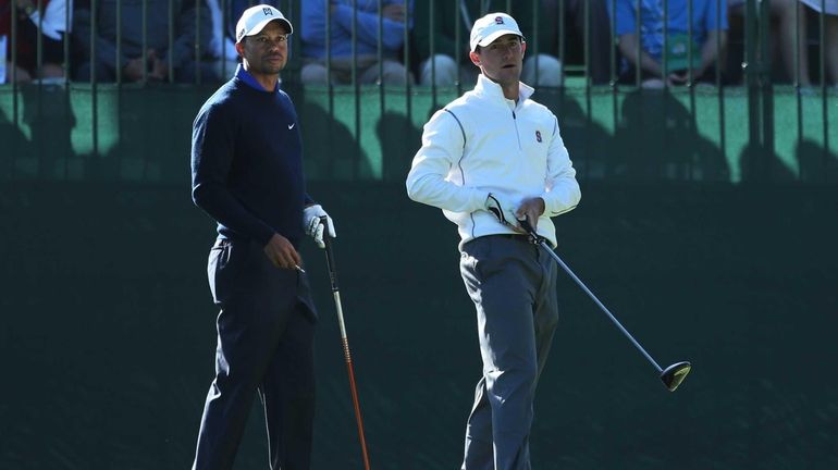 Amateur Cameron Wilson, right, watches his tee shot alongside Tiger...