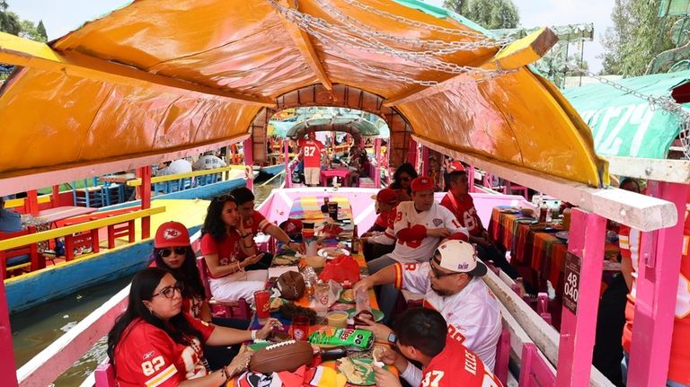 Kansas City Chiefs fans ride on "trajinera" boats along the...