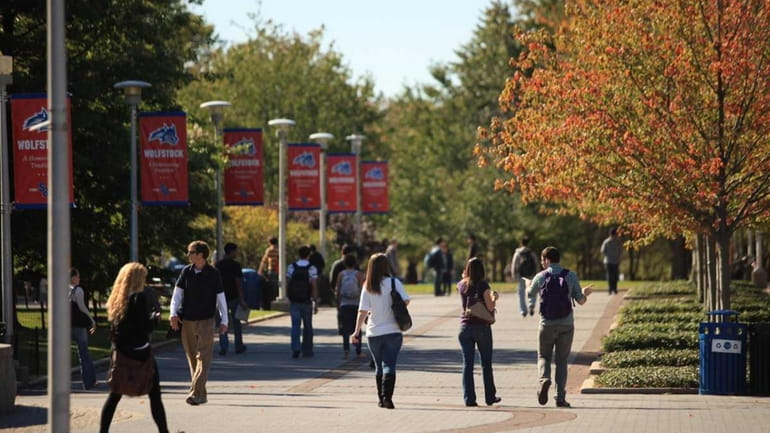 Students walk along the Academic Mall on the campus of...