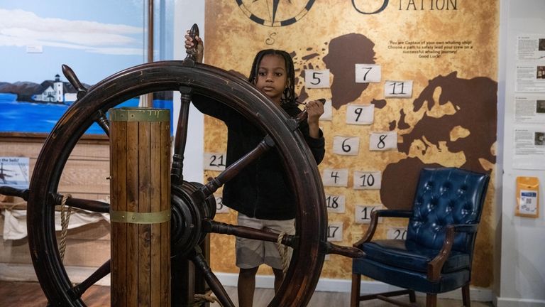 Zane Marchan, 6, from Valley Stream, steers a ship wheel...