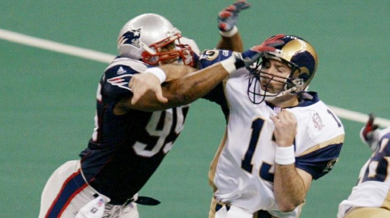 Patriots linebacker Roman Phifer blocks a pass attempt by Rams...