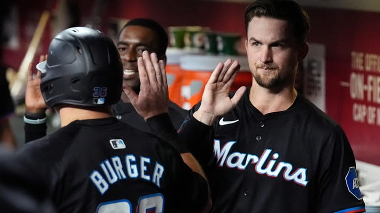 Miami Marlins' Jake Burger, left, gets a high-five from Marlins'...