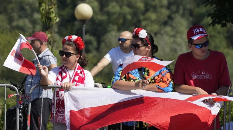 People wait for a massive military parade during the Polish...