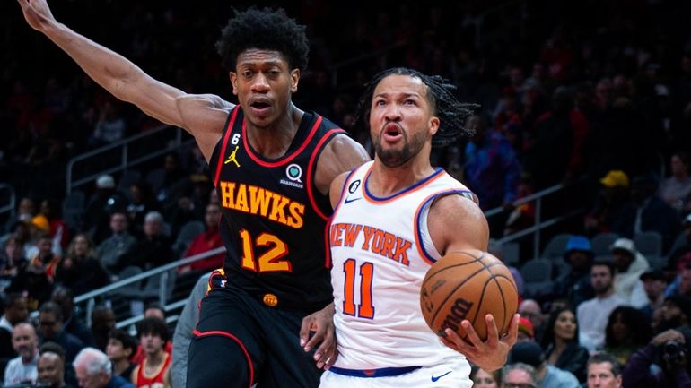 Knicks guard Jalen Brunson drives past Hawks forward De'Andre Hunter...