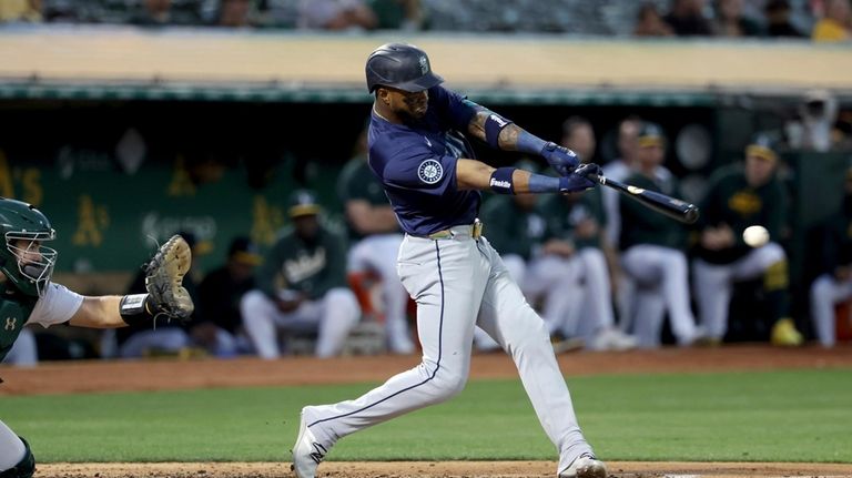 Seattle Mariners outfielder Victor Robles, right, hits a double in...