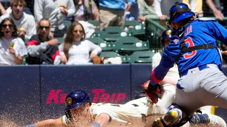 Milwaukee Brewers' Sal Frelick slides safely past Chicago Cubs catcher...