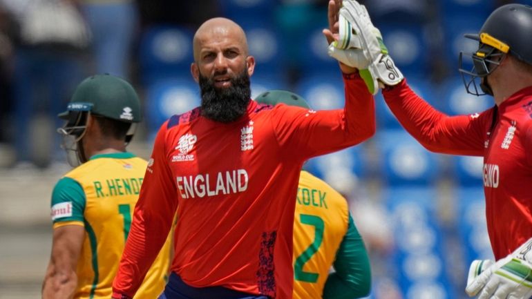 England's Moeen Ali, center, celebrates with captain Jos Buttler after...