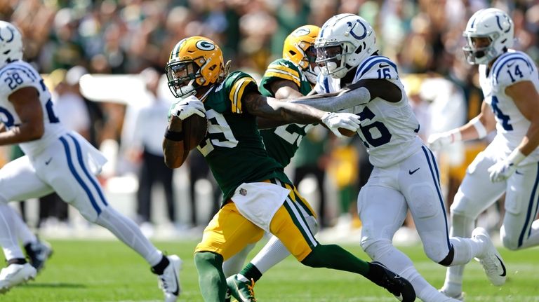 Green Bay Packers safety Xavier McKinney (29) tries to escape...