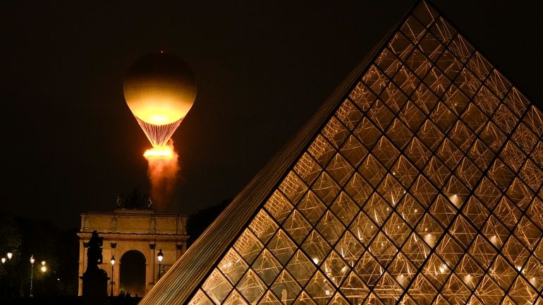 The Olympic Flame rises on a balloon after being lit...