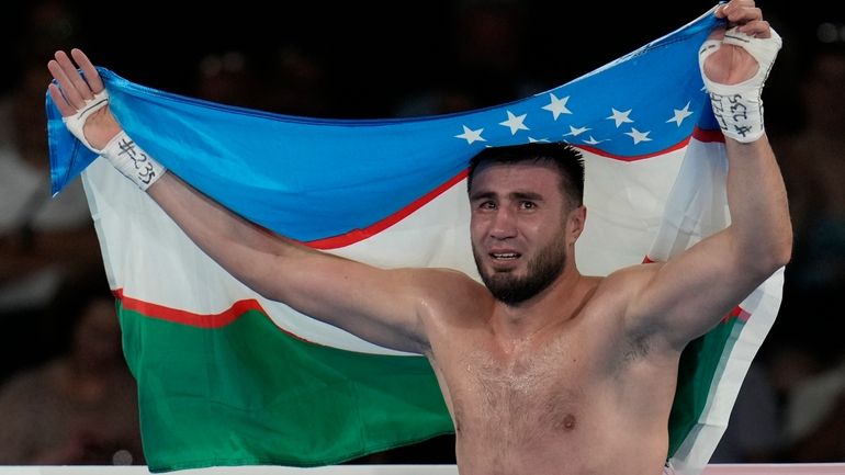 Uzbekistan's Bakhodir Jalolov celebrates after defeating Spain's Ayoub Ghadfa in...