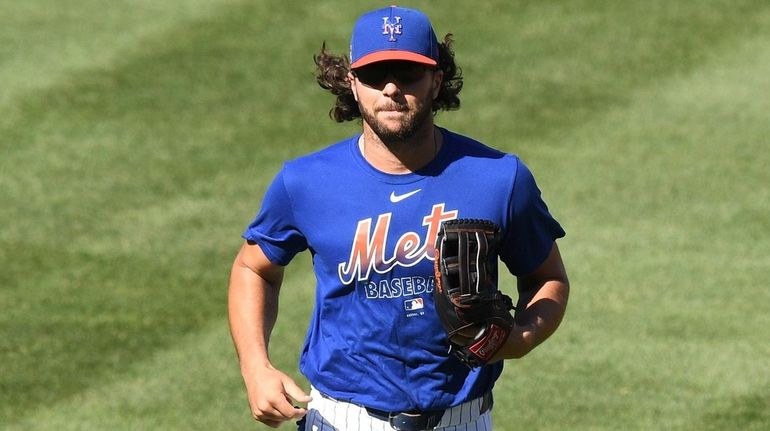 The Mets' Jake Marisnick runs in from the outfield during a...