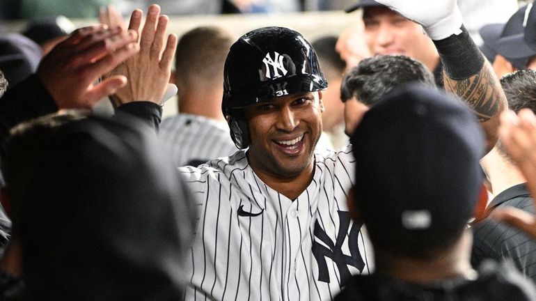 The Yankees' Aaron Hicks is greeted in the dugout after...