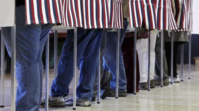 Residents vote for their candidates at a voting booth on...