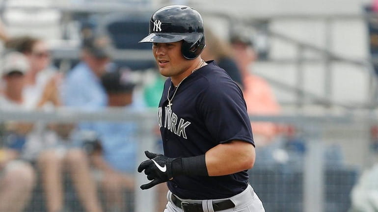 Luke Voit of the Yankees rounds the bases after hitting...