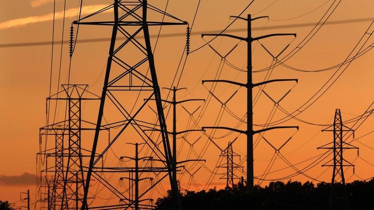 Transmission towers carry power lines through Suffolk County on Monday,...