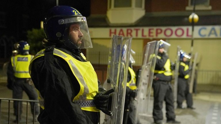 Police officers stand guard on the streets of Hartlepool, England,...