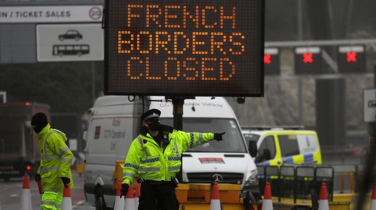 A police officer directs traffic at the entrance to the...