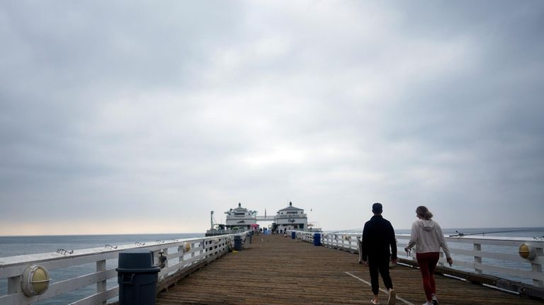 Visitors walk on the pier Thursday, Sept. 12, 2024, in...