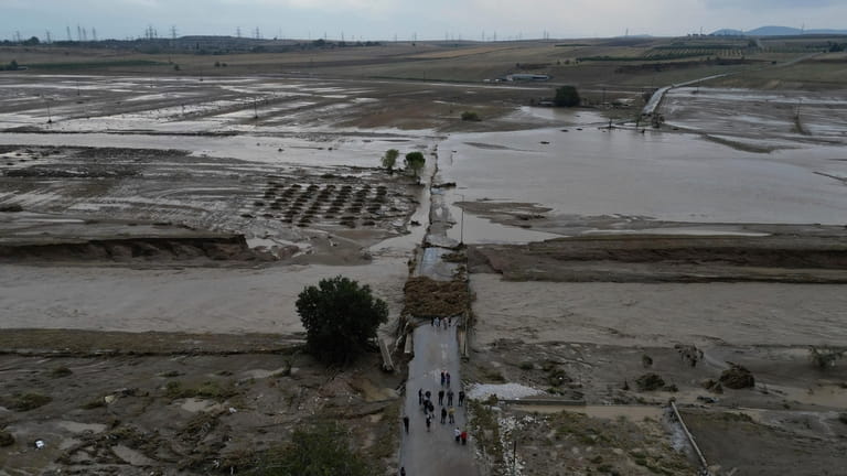 Floodwaters and mud cover the land after the country's record...