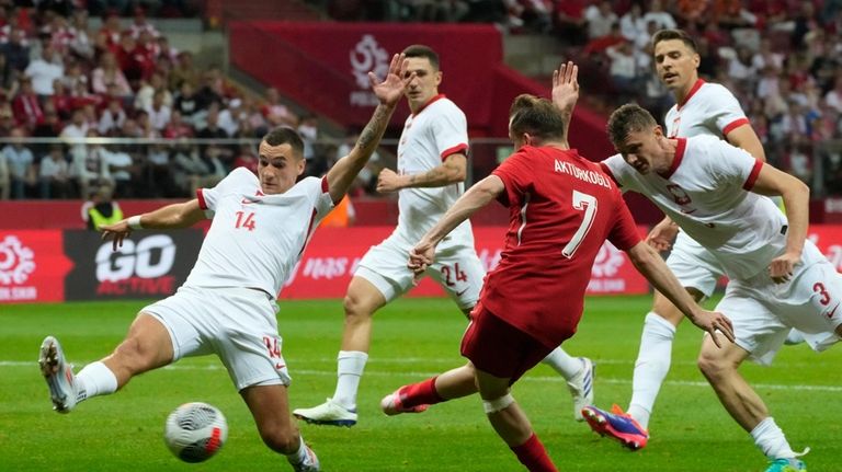 Turkey's Kerem Akturkoglu, centre, makes an attempt to score during...