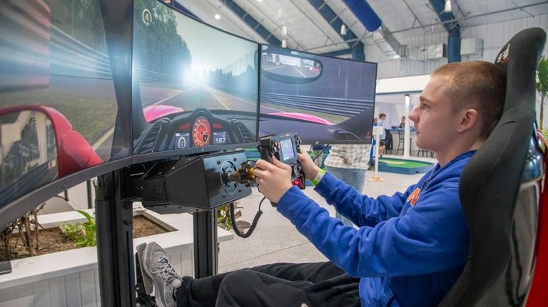 Tom Pagne, 16, of Southampton plays a driving simulator at...