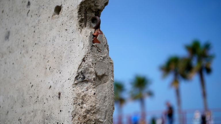 A slab of the Berlin Wall is displayed near the...