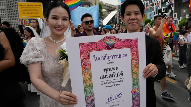 Participants hold posters celebrating equality in marriage during the Pride...