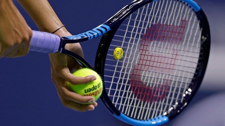 A tennis player serves during a match at the U.S....