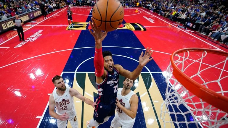 Philadelphia 76ers' Tobias Harris, center, goes up for a shot...