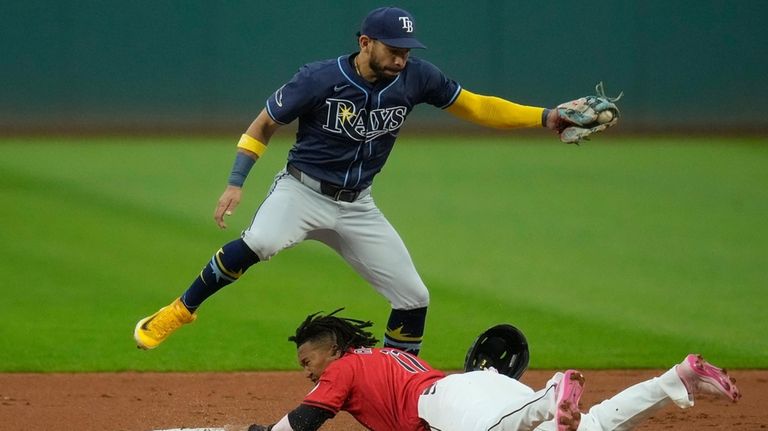 Cleveland Guardians' José Ramírez, bottom, steals second base as Tampa...