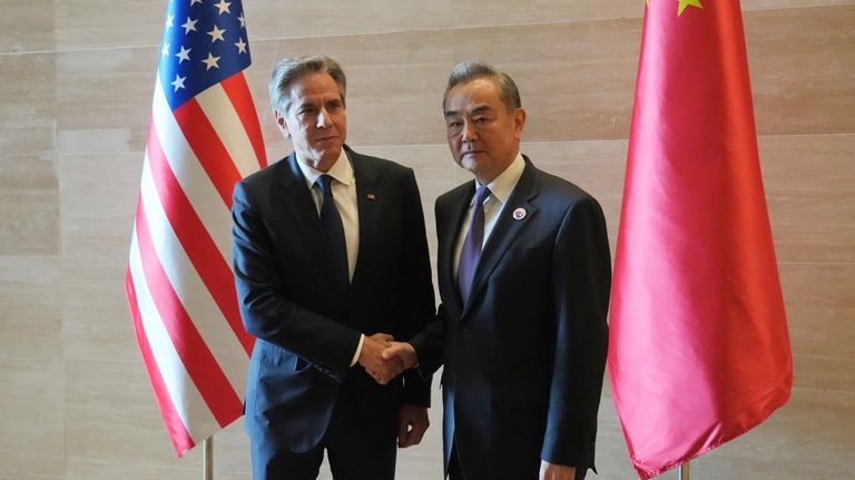 U.S. Secretary of State Antony Blinken, left, shakes hands with...