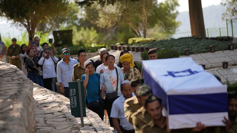 Family follow as Israeli soldiers carry the casket of first...