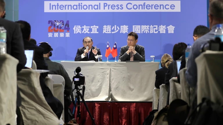 Taiwan's Nationalist Party presidential candidate Hou Yu-ih, left, answers to...