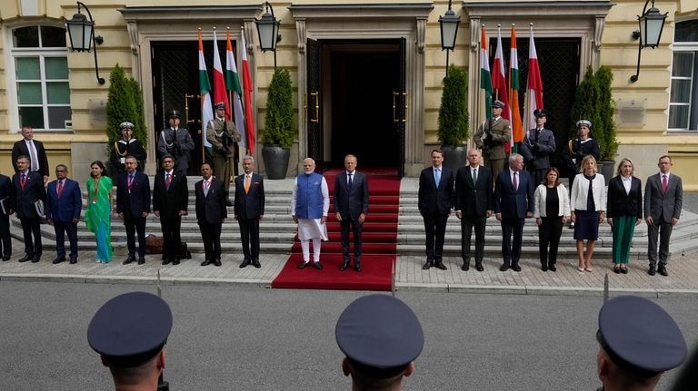 Indian Prime Minister Narendra Modi, center left in blue, stands...